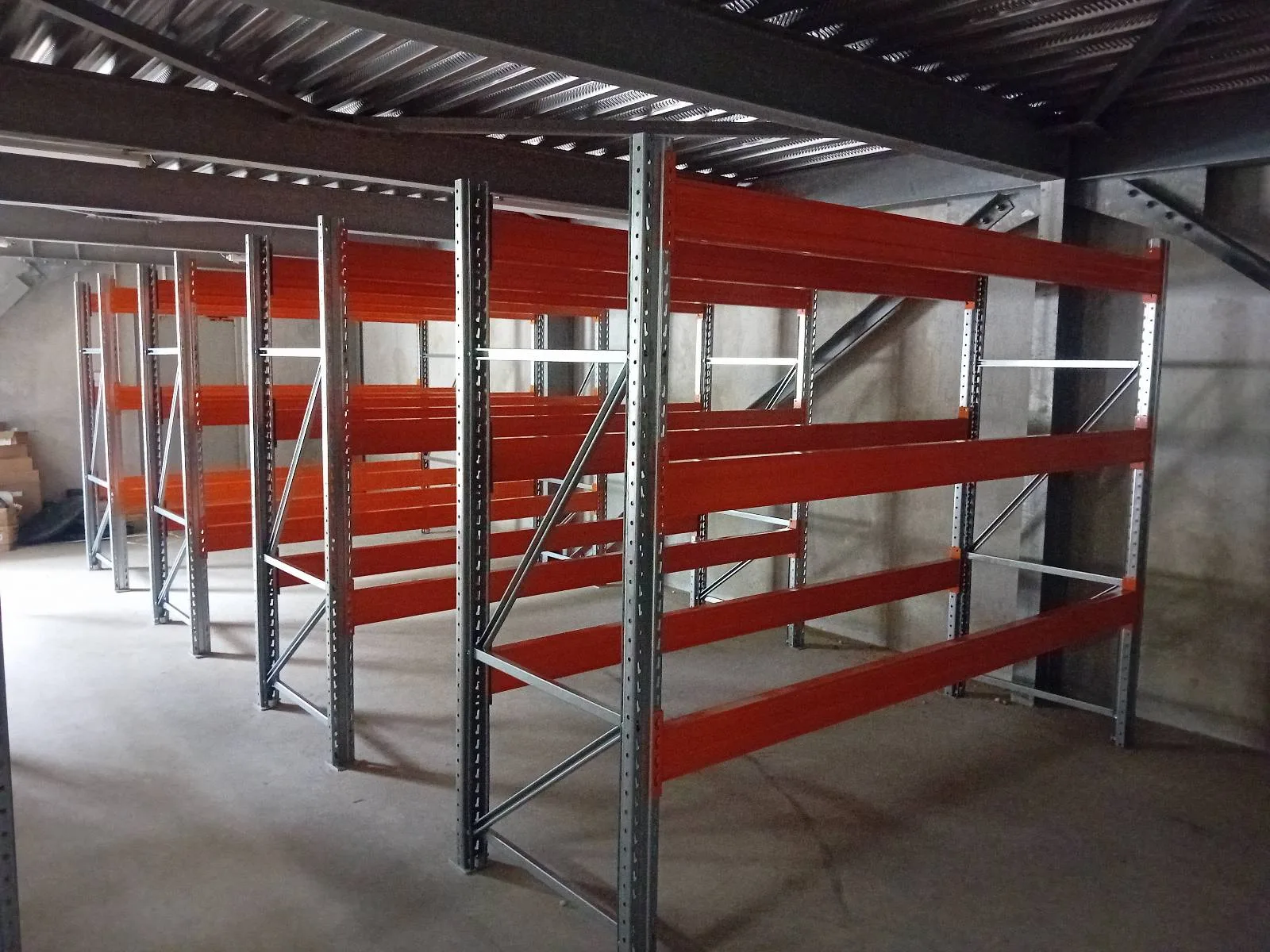 Vue large des travées de racks lourds basse hauteur au montage, sous la mezzanine du nouveau site SEA SOMANET à la Semair, Le Robert (Martinique)