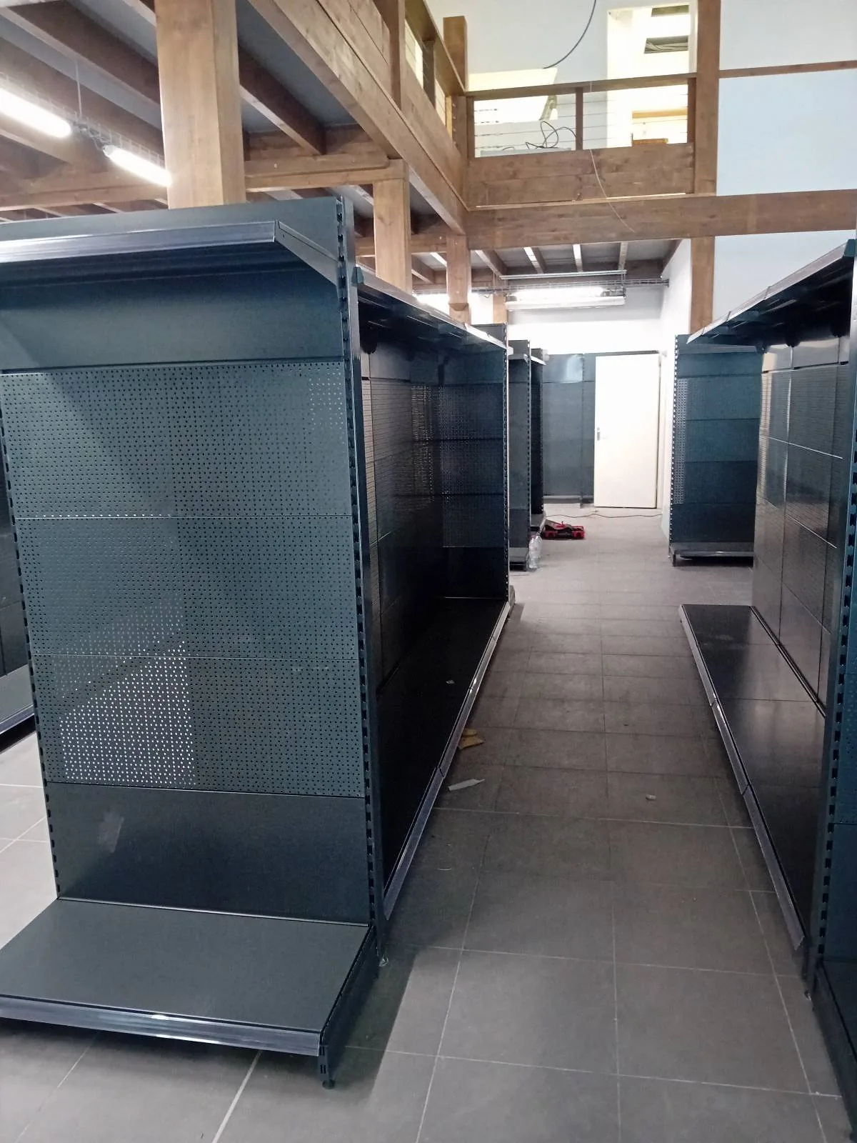 Allée centrale entre deux gondoles de magasin anthracite dans le nouveau magasin AKWABA à Jarry, Baie-Mahault (Guadeloupe)