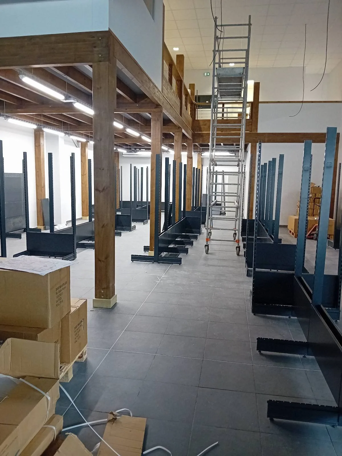 Enfilade des gondoles centrales montées entre les poteaux bois de la surface de vente AKWABA à Jarry (Guadeloupe)