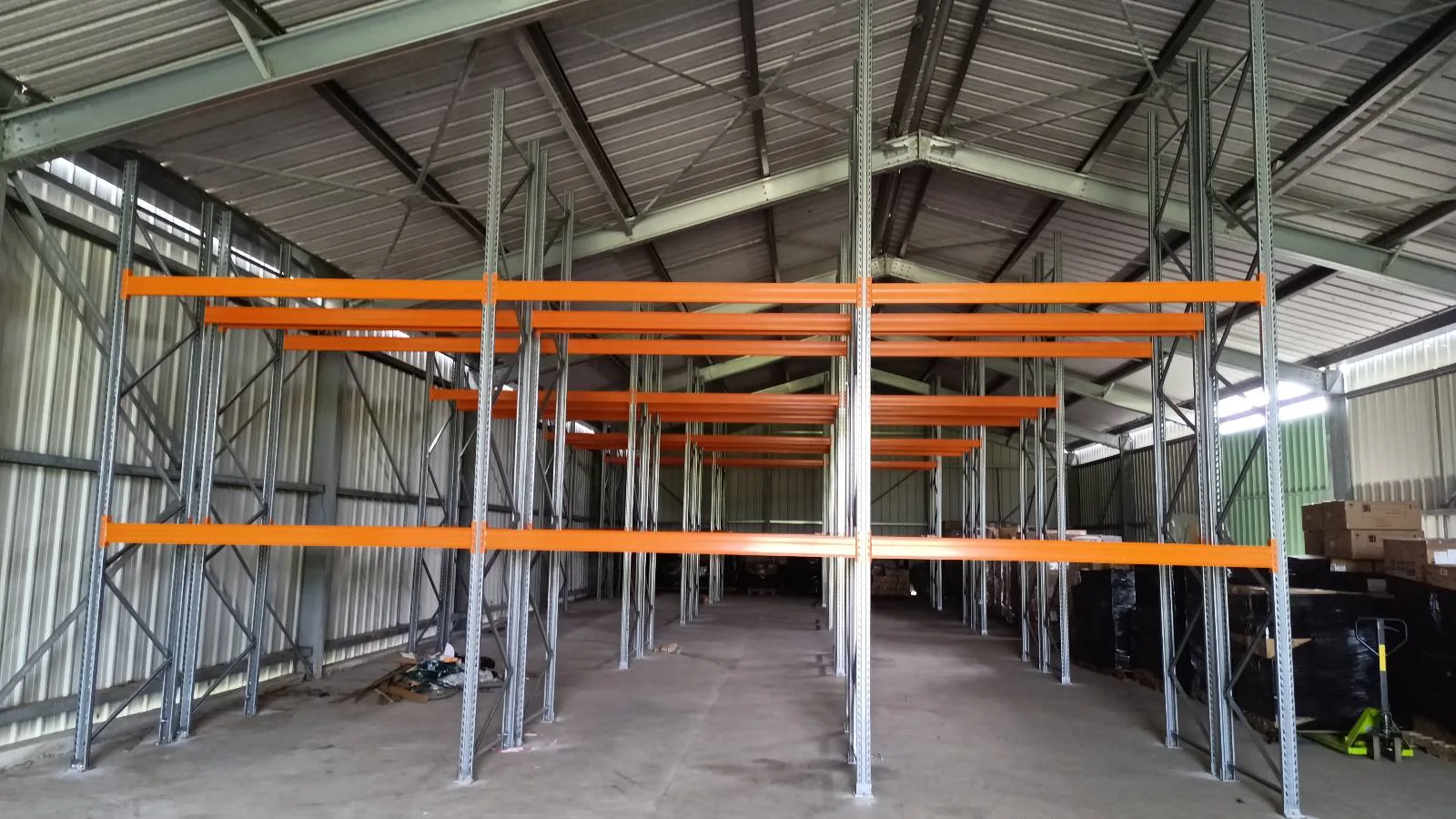Racks à palettes avec échelles galvanisées et lisses orange vus de face dans le dépôt QUEEN Super Center à Rivière-Salée (Martinique)